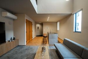 福岡市にあるTRIGON Hotel FUKUOKAのソファとテーブルのあるリビングルーム
