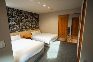 福岡市にあるTRIGON Hotel FUKUOKAのベッドルーム1室(ベッド2台、鏡付)