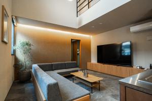 福岡市にあるTRIGON Hotel FUKUOKAのソファとテレビのあるリビングルーム