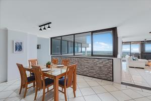 a dining room with a table and chairs in a house at Maroochydore Riverfront Apartment in Maroochydore