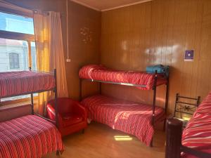 una habitación con tres literas y una ventana en Hostel La Morenita, en Punta Arenas