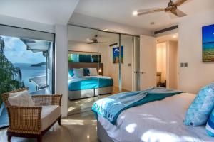 ハミルトン島にあるEdge 16 - Hamilton Island - Waterfront, Golf Buggy and Sea Viewsのベッドがあり海が見える寝室