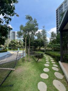a park with a net and some grass and trees at MayaBay Residence Splash Mania Gamuda Cove Homestay by Ara in Pulau Kempas