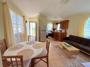 a kitchen and living room with a table and a couch at Hill Top Cottage in Friar's Bay
