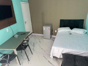 帕苏丰杜Flats &Residences - Studio Moderno e Completo的一间卧室，配有一张床、一张书桌和一台电脑