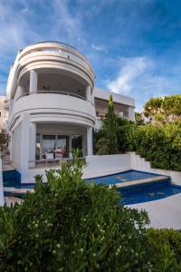 een groot wit huis met een zwembad ervoor bij Villa Perla Baska in Baška