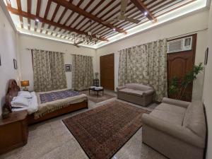 a bedroom with a bed and a couch and a table at Mulberry Garden in Varanasi