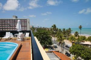 balcón con piscina y vistas a la playa en Flat Mar do Cabo Branco Residence, en João Pessoa