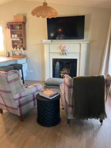 a living room with two chairs and a fireplace at Gate Keepers Cottage in Tasman