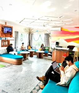 a group of people sitting on couches in a room at GreenDay Escapes Rishikesh in Rishīkesh