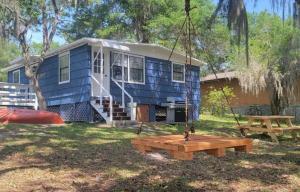 a blue tiny house with a picnic table at Relaxed Lake Front Cottage 2 Bedrooms Sleeps 6 Pet Friendly in Keystone Heights