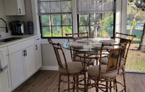 a kitchen with a glass table and four chairs at Relaxed Lake Front Cottage 2 Bedrooms Sleeps 6 Pet Friendly in Keystone Heights +11 photos