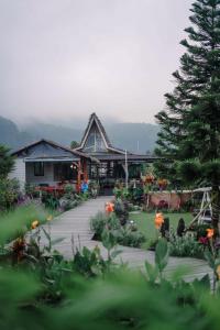 a house with a walkway in front of a garden at Pondanu Cabins By The Lake in Bedugul