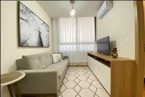 a living room with a couch and a tv at Central, Ar Cond, WI-FI, Lava e Seca in Santa Maria