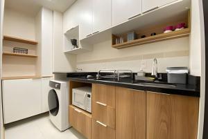 a kitchen with a sink and a microwave at Central, Ar Cond, WI-FI, Lava e Seca in Santa Maria +4 photos