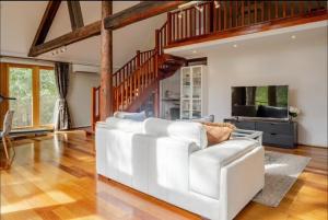 a living room with a white couch and a staircase at Bickley Tree Stay in Bickley