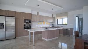 a kitchen with wooden cabinets and a white counter top at Aretousa Ena by Prestige Bookings in Peyia