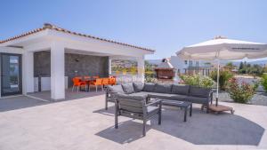 a living room with a couch and an umbrella at Aretousa Ena by Prestige Bookings in Peyia