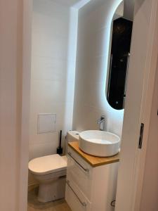 Apartament centrum في بياويستوك: حمام أبيض مع حوض ومرحاض