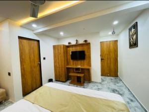 a bedroom with a large bed and a tv at Hotel Skyland in Ahmedabad