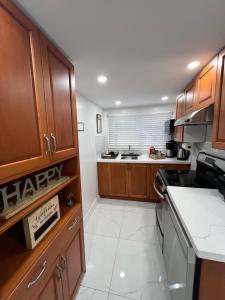 a kitchen with wooden cabinets and a white tile floor at Niagara Escape Loft in St. Catharines
