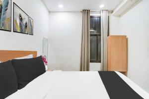 a bedroom with a black and white bed and a window at Super Townhouse Jagatpura Formerly Hotel Soft Patel in Jaipur +21 photos
