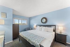 パナマ・シティ・ビーチにあるThe Summit 505 - Luxury Beach Resort Condo - Beachfront - FREE BEACH CHAIRS AND SUNSHADEの青い壁のベッドルーム1室(大型ベッド1台付)
