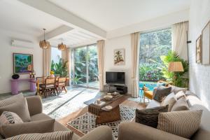 a living room with a couch and a tv at La Verona by The Blue Kite - 2 & 3 BHK Villas in Assagao with Private Pool, Garden, Caretaker, Kitchen & Security in Assagao