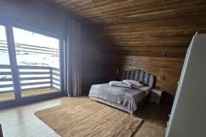 a bedroom with a bed and a large window at Poiana Brazilor in Poiana Negrii +22 photos