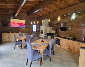 a dining room with wooden tables and chairs and a fireplace at Poiana Brazilor in Poiana Negrii