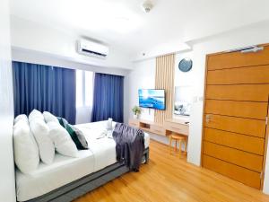 ein Schlafzimmer mit Bett, Schreibtisch und Fernseher in der Unterkunft 34B Taft East Gate 2 Bedroom Unit Pool, Gym, Balcony in Cebu City