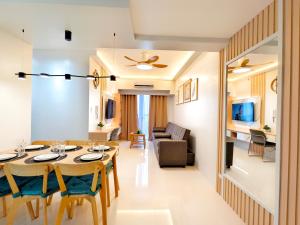 ein Esszimmer und ein Wohnzimmer mit Tisch und Stühlen in der Unterkunft 34B Taft East Gate 2 Bedroom Unit Pool, Gym, Balcony in Cebu City + 83 Fotos