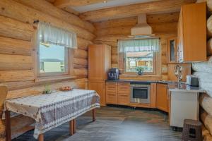 a kitchen with wooden walls and a table in a room at Prosilva House Banffy in Topliţa