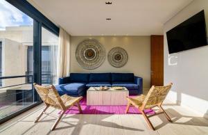 a living room with a blue couch and two chairs at Xielo in Tulum
