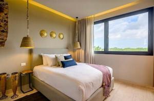 a bedroom with a large bed and a large window at Xielo in Tulum +17 photos