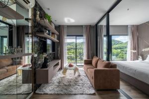 Ban Fang DaengMountain-view 1BR 9F Sriracha byน้องมังคุด NoParking的一间带沙发、床和窗户的卧室