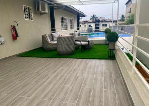 a patio with chairs and a table on a balcony at Scarlett Apartments in Monrovia