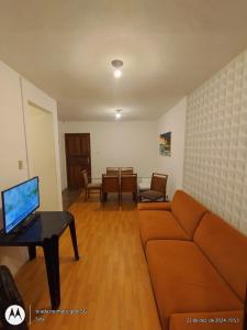a living room with a couch and a table with a laptop at Centro de Convenções - Hospedagem in Recife