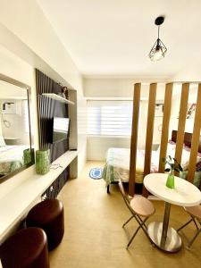 a bedroom with a bed and a table and chairs at Avida Towers Condo Near Peoples Park and Roxas Night Market in Davao City