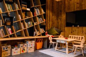 Zimmer mit einem Tisch und Regalen mit Büchern in der Unterkunft Pataunerhof Betulla Quercus in Dorf Tirol
