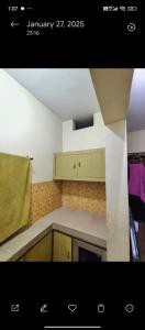 a small kitchen with a counter top and a kitchenestamp at Kumbh room in Muthiganj