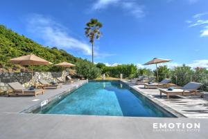 a swimming pool with lounge chairs and umbrellas at New Seaside Elegance Luxury Villa in Oyster Pond - December 2024 renovated in Oyster Pond