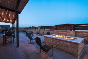 a fire pit on a patio with chairs and tables at Courtyard Dallas Grand Prairie in Grand Prairie