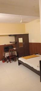 a bedroom with two beds and a table and a chair at Tabish INN in Trivandrum +2 photos
