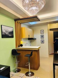 a kitchen with a counter and two stools in a room at Avida Atria Tower 4 in Iloilo City +11 photos