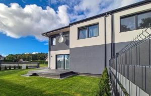a house with a fence and a grass yard at Stunning Home In Kamien Pomorski in Kamień Pomorski +14 photos