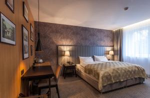 a hotel room with a bed and a desk at Hotel pod Lipou RESORT in Modra