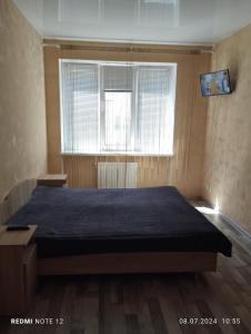 a bedroom with a large bed in front of a window at Mineralna Apartment 49 in Irpin'