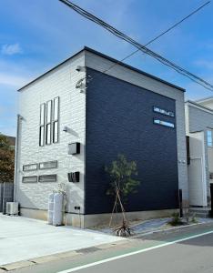 a brick building with a large blue garage at 8Room-千葉県八街市 in Yachimata