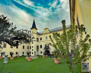 a large white building with a large yard with plants at Schloss Hubertendorf Apartment in Blindenmarkt